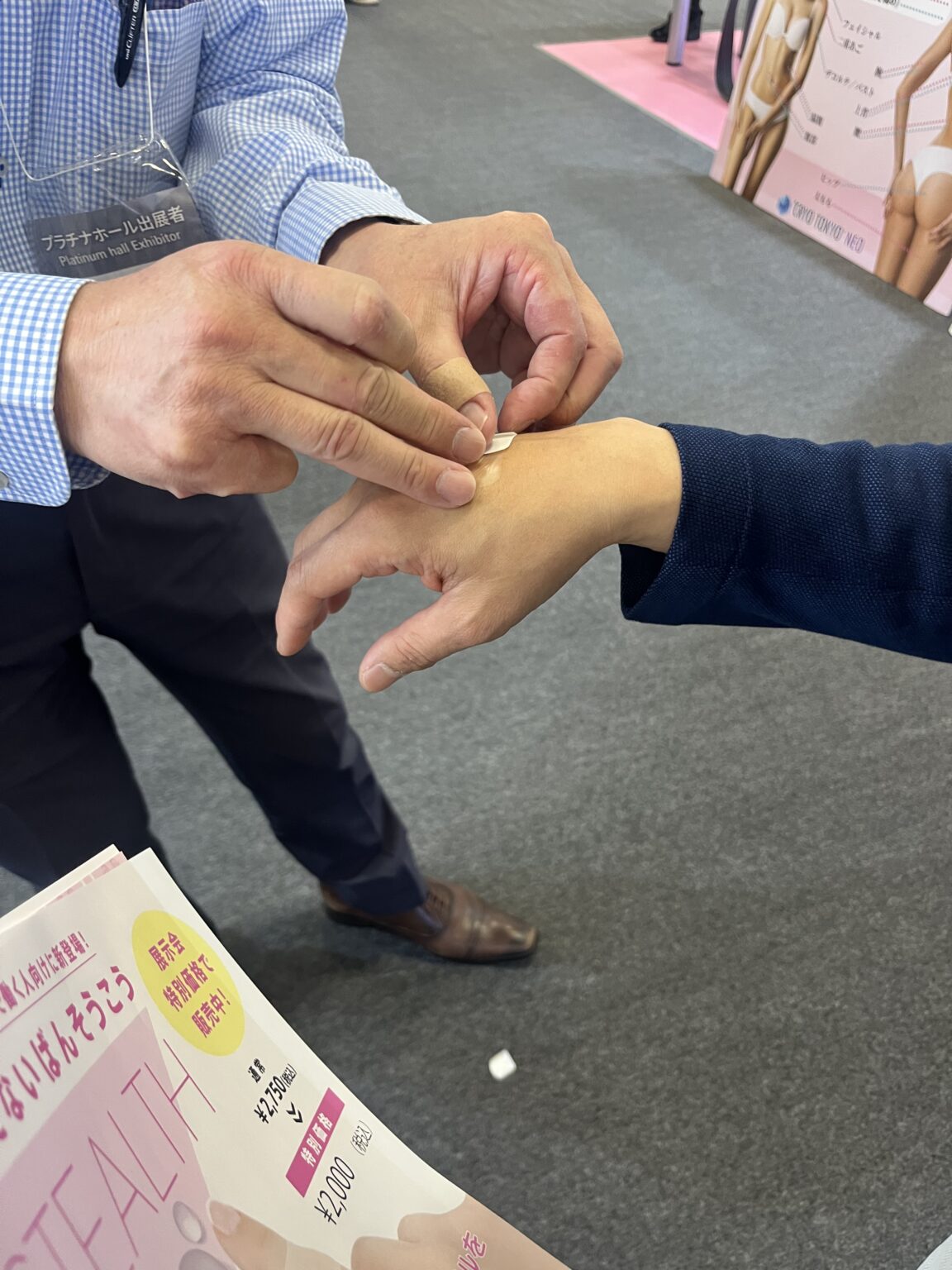 展示会で日焼け止めを塗ってもらうスタッフ